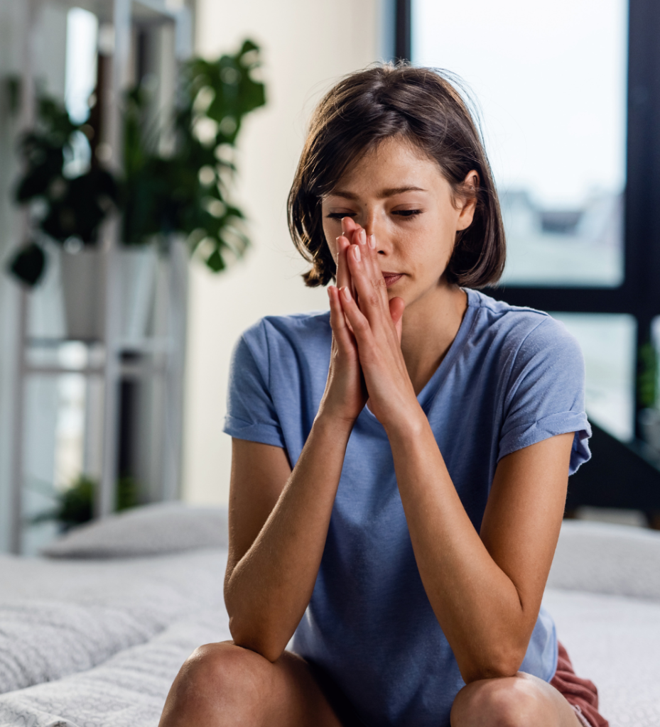 Woman looking stressed with hands clasped