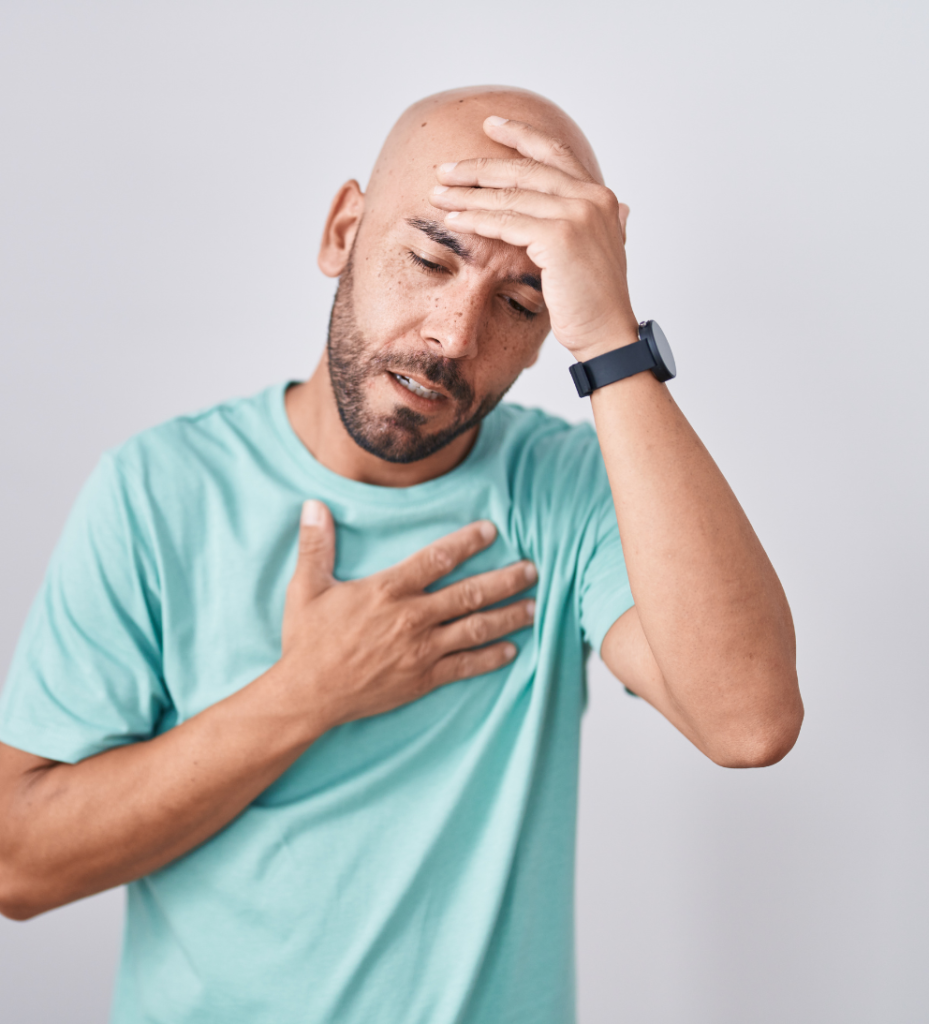 Man holding chest and head in discomfort