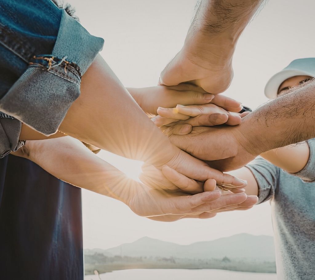 Group of people stacking hands together